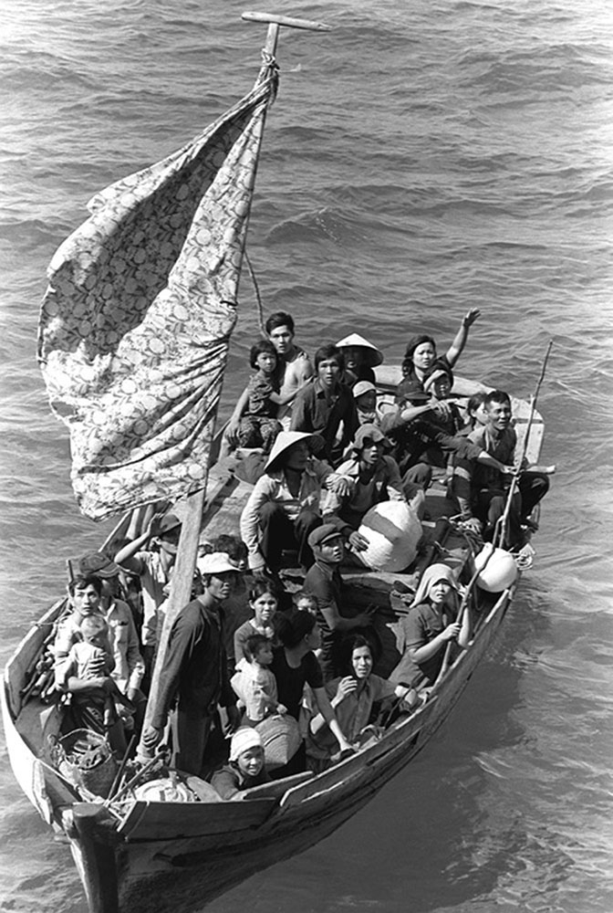 図11.10 | 35人のベトナム難民が米軍水陸両用艦USSブルーリッジ(LCC-19)に収容されるのを待っています。彼らは8日間海上で過ごした後、ベトナムのカムラン湾の北東350マイルの地点で35フィートの漁船から救助されるところです。(Credit: U.S. Navy/Wikimedia Commons)
