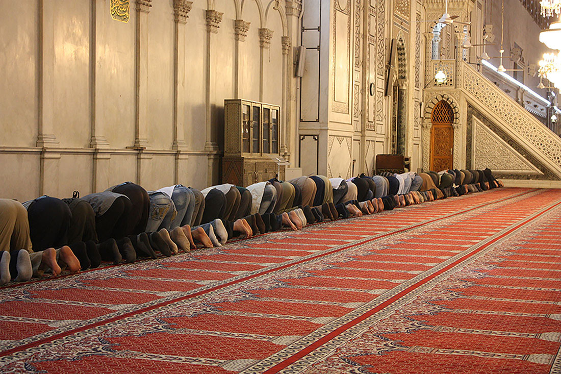 図15.2 | ダマスカスにあるウマイヤド・モスクでの礼拝のような宗教的実践の普遍性は、それがなければ赤の他人であったような人々の間に絆を生み出すことができます。世界中のイスラム教徒は毎日五回、メッカのカーバの方角を向いて祈りを捧げます(15.2節の写真を参照)。宗教的な行事を超えて、このような一体感のある行為は、強力な共同体意識を築くことができます。(Credit: Arian Zwegers/flickr)